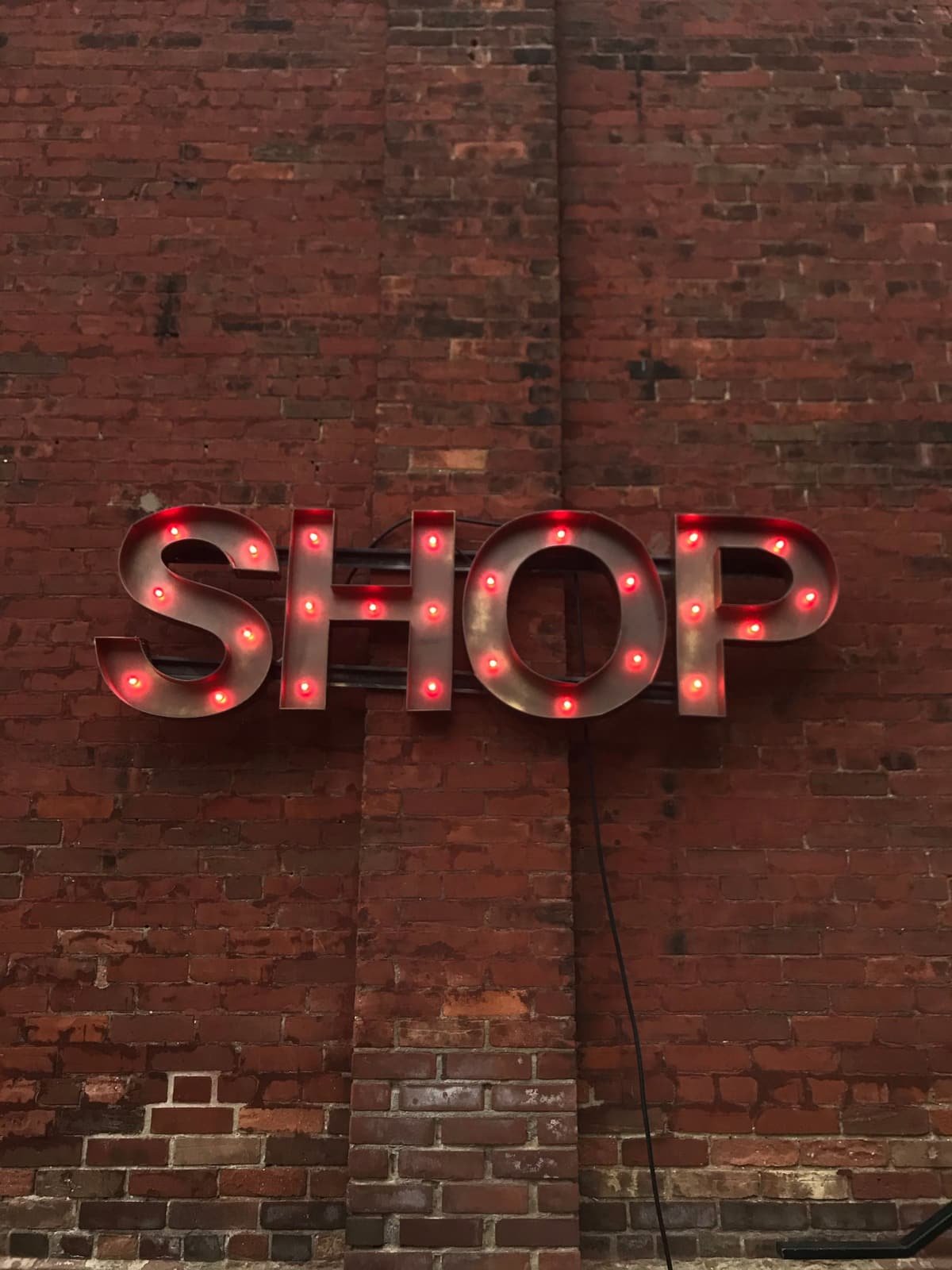 Letras volumétricas metálicas con iluminación instaladas sobre muro de ladrillo