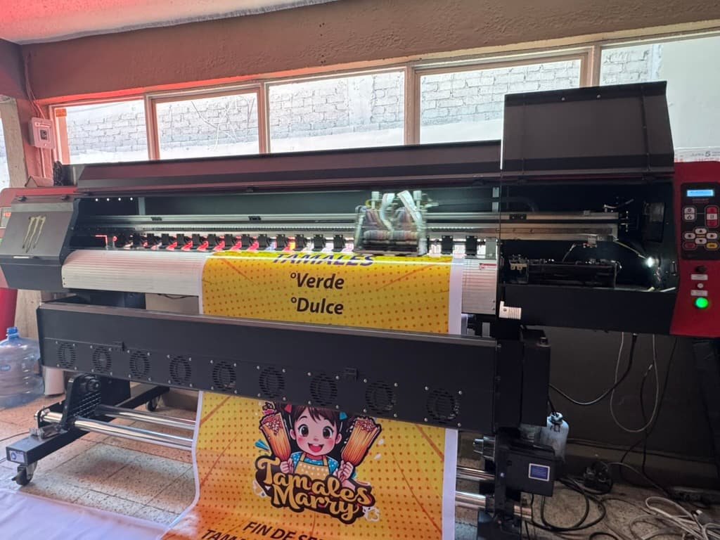 Lona publicitaria a todo color imprimiéndose en el plotter de gran formato de la planta